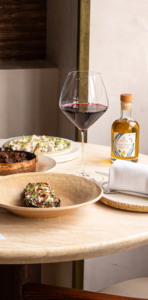 Image of a central table at Myrtos by Asimakis set with glasses and cutlery for a London wine tasting evening.